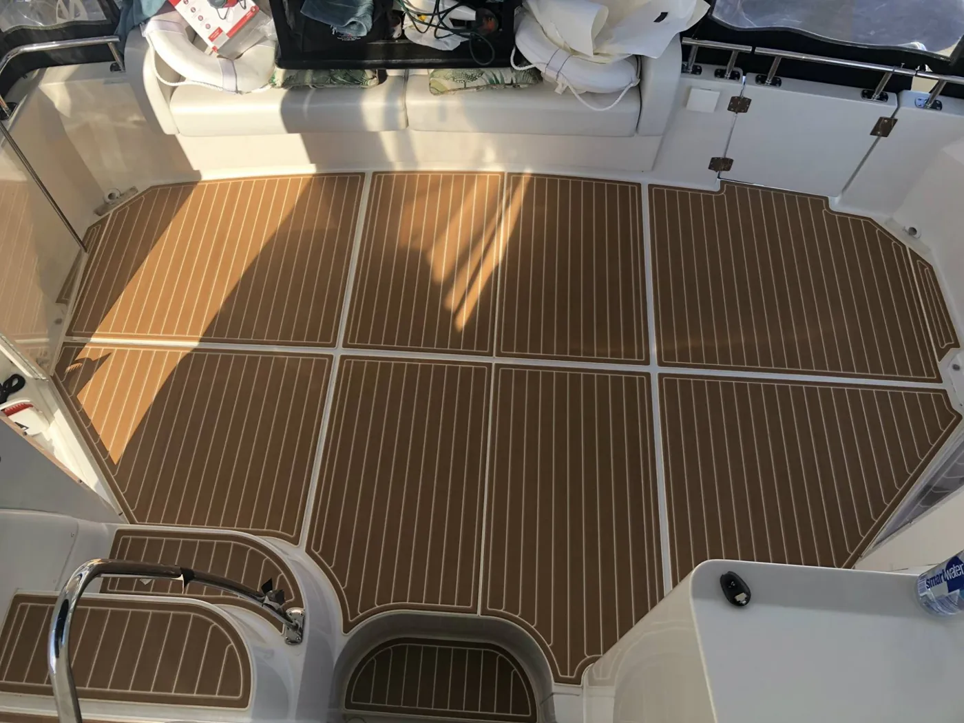 Cockpit deck covered in brown faux-teak foam decking with white seam lines