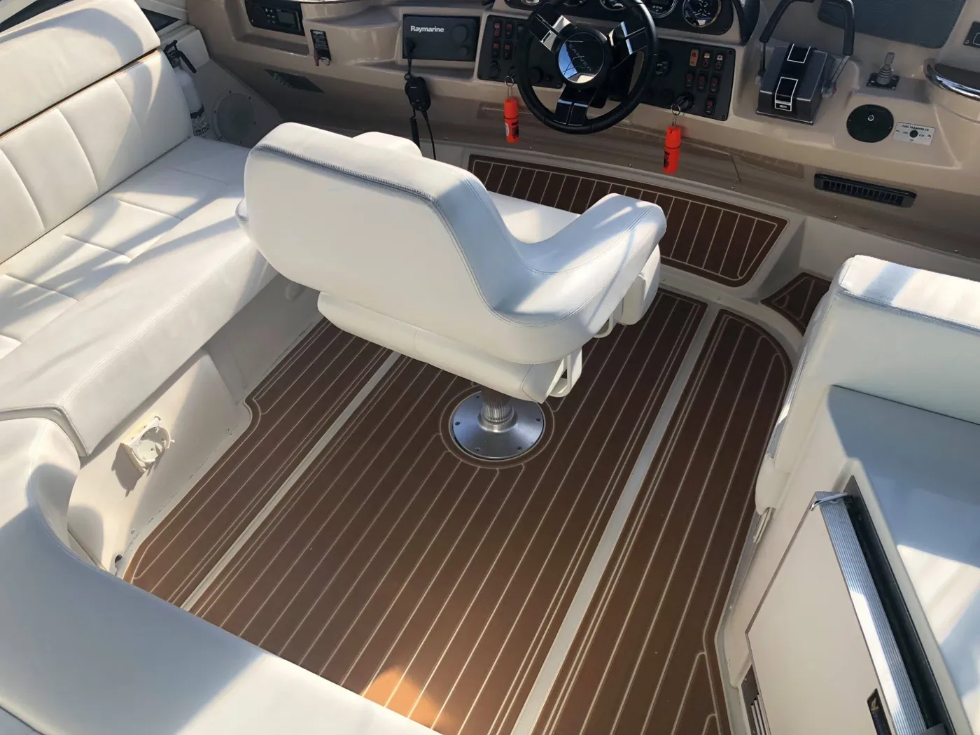 Helm station floor fitted with dark faux-teak decking around the captain's chair